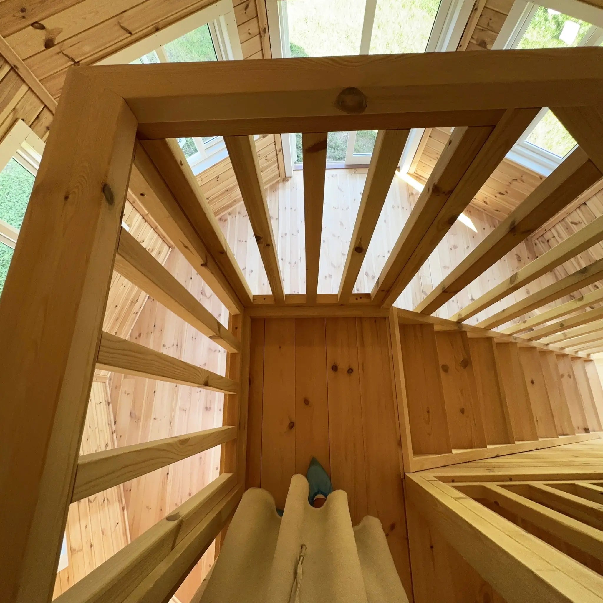 Timber staircase leading to the loft with open risers and handrail inside the Altura Loft Cabin