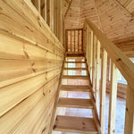 Side view of the staircase with vertical timber balustrade and wall panelling in the Altura Loft Cabin