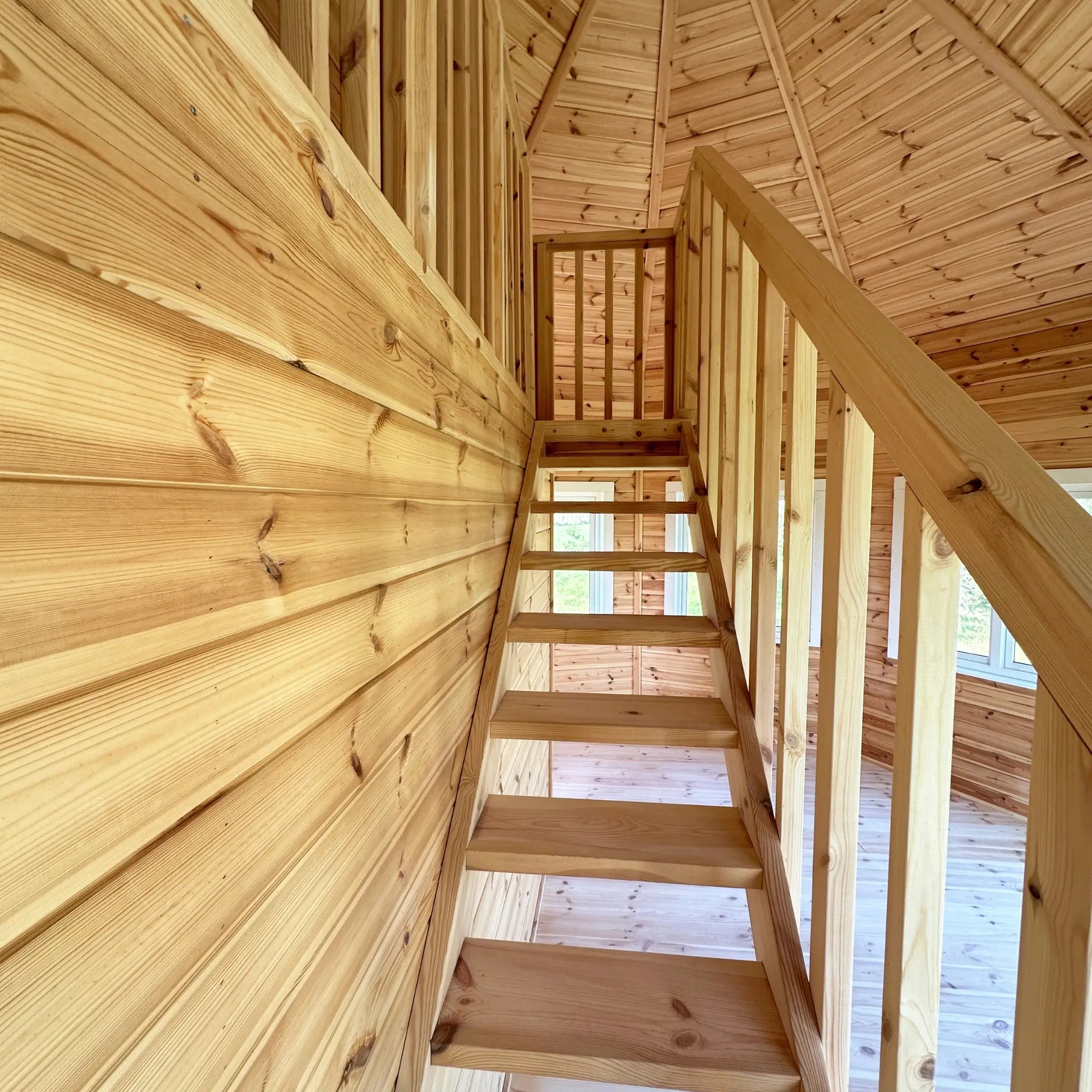 Side view of the staircase with vertical timber balustrade and wall panelling in the Altura Loft Cabin