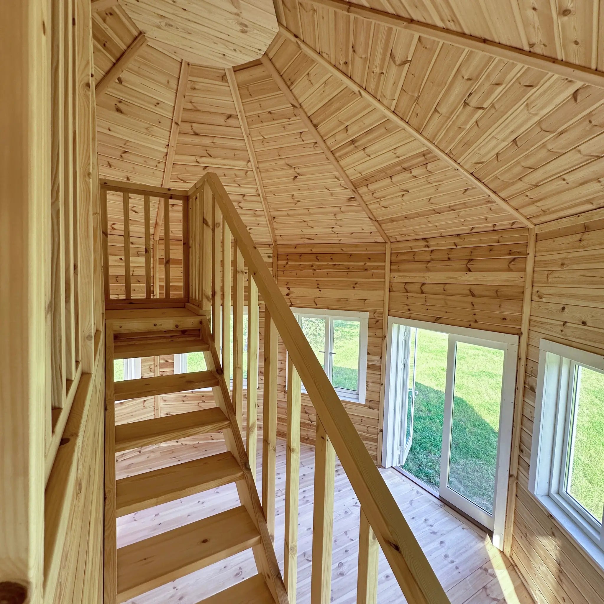 Staircase and loft entrance with panoramic windows and natural timber interior in the Altura Loft Cabin