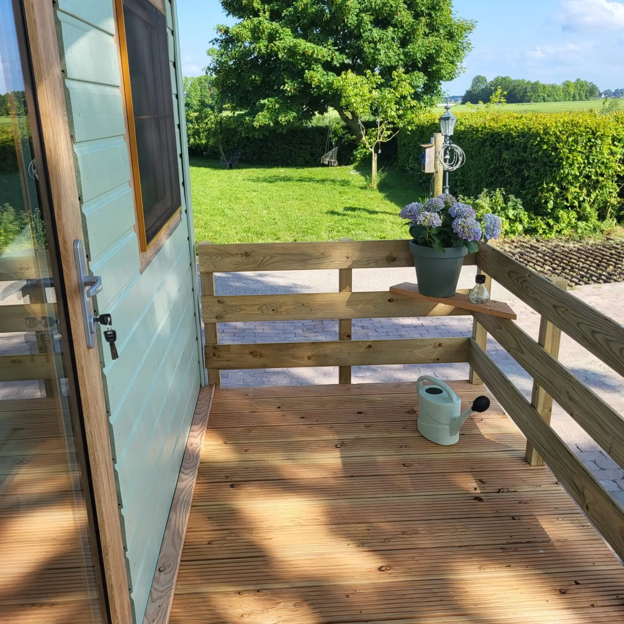 Deck corner view overlooking countryside from the Archwood shepherd’s hut