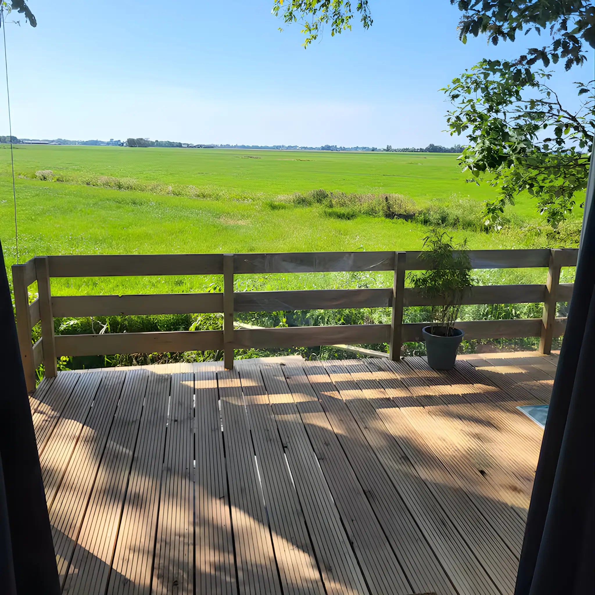Deck view looking out to countryside landscape from shepherd’s hut