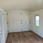 Interior view showing storage cupboards inside the Archwood shepherd’s hut