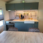 Modern kitchenette and dining table inside Archwood glamping shepherd’s hut