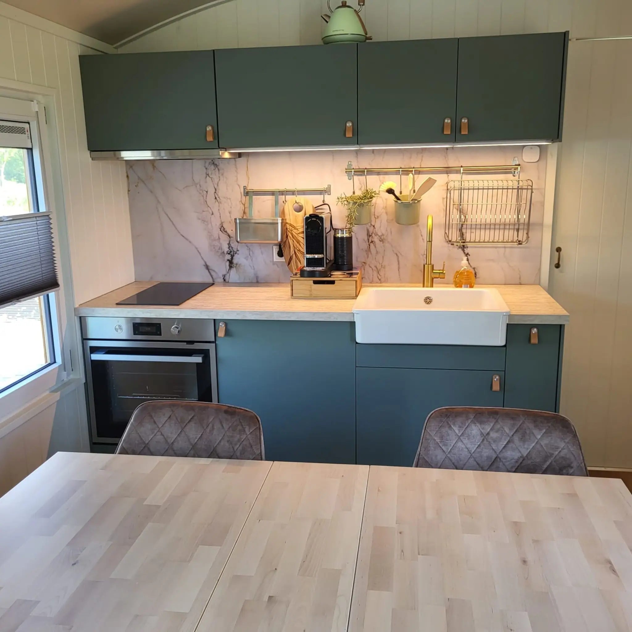 Modern kitchenette and dining table inside Archwood glamping shepherd’s hut