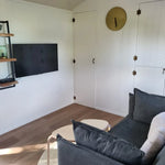 Wall mounted TV and lounge seating inside the Archwood shepherd’s hut interior