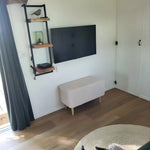 Minimalist TV wall with shelving inside the Archwood glamping shepherd’s hut