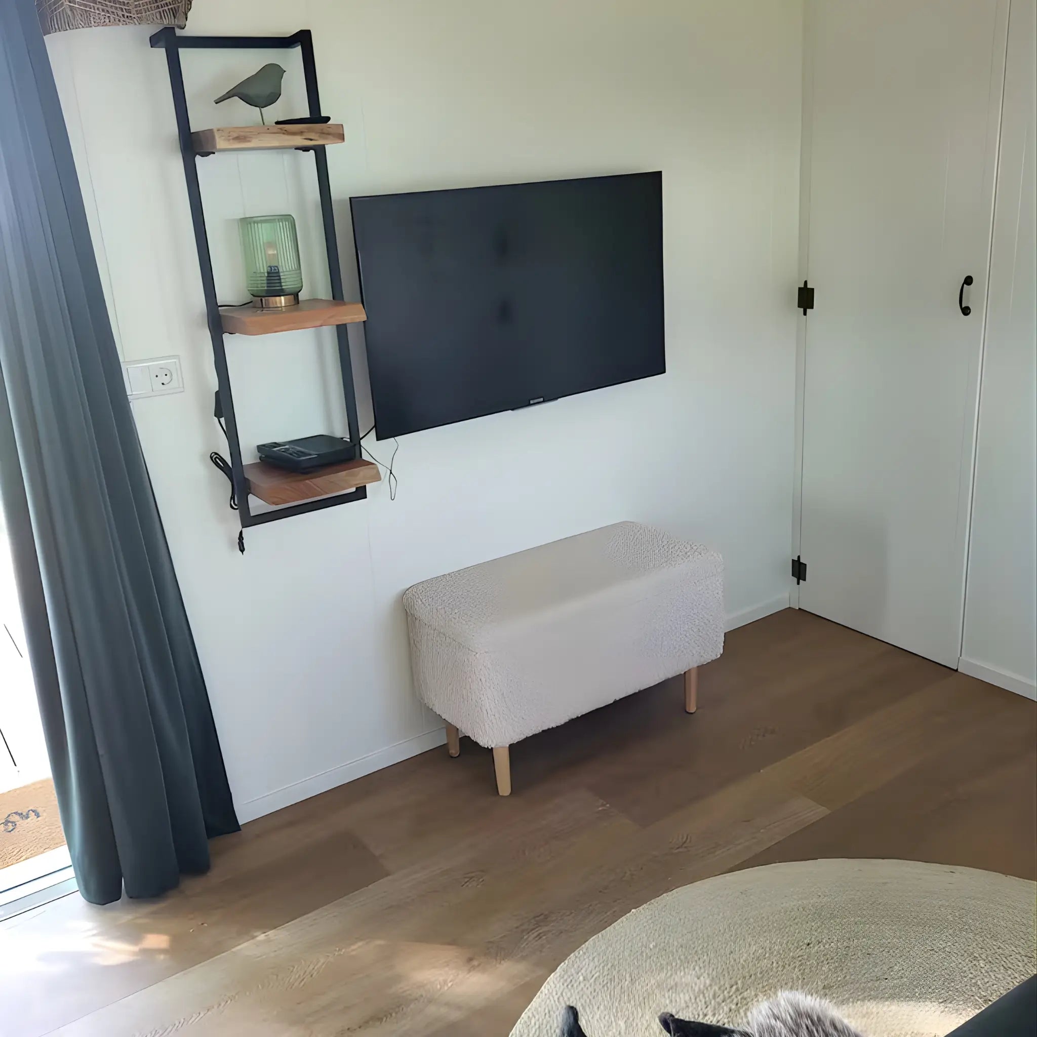 Minimalist TV wall with shelving inside the Archwood glamping shepherd’s hut