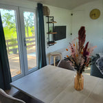 Living area with sofa and patio doors inside the Archwood shepherd’s hut