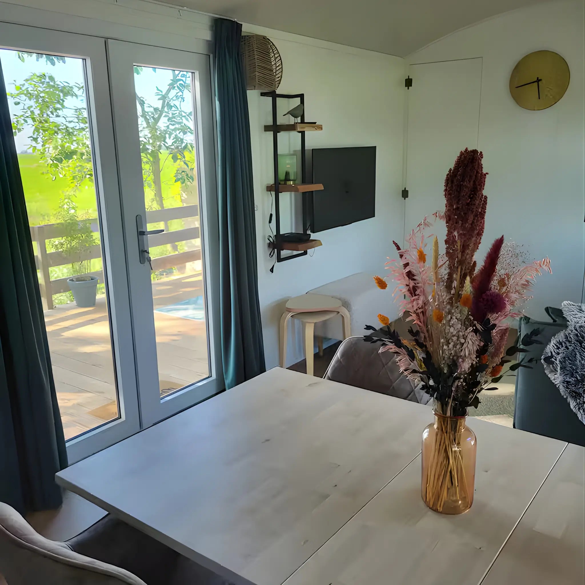 Living area with sofa and patio doors inside the Archwood shepherd’s hut