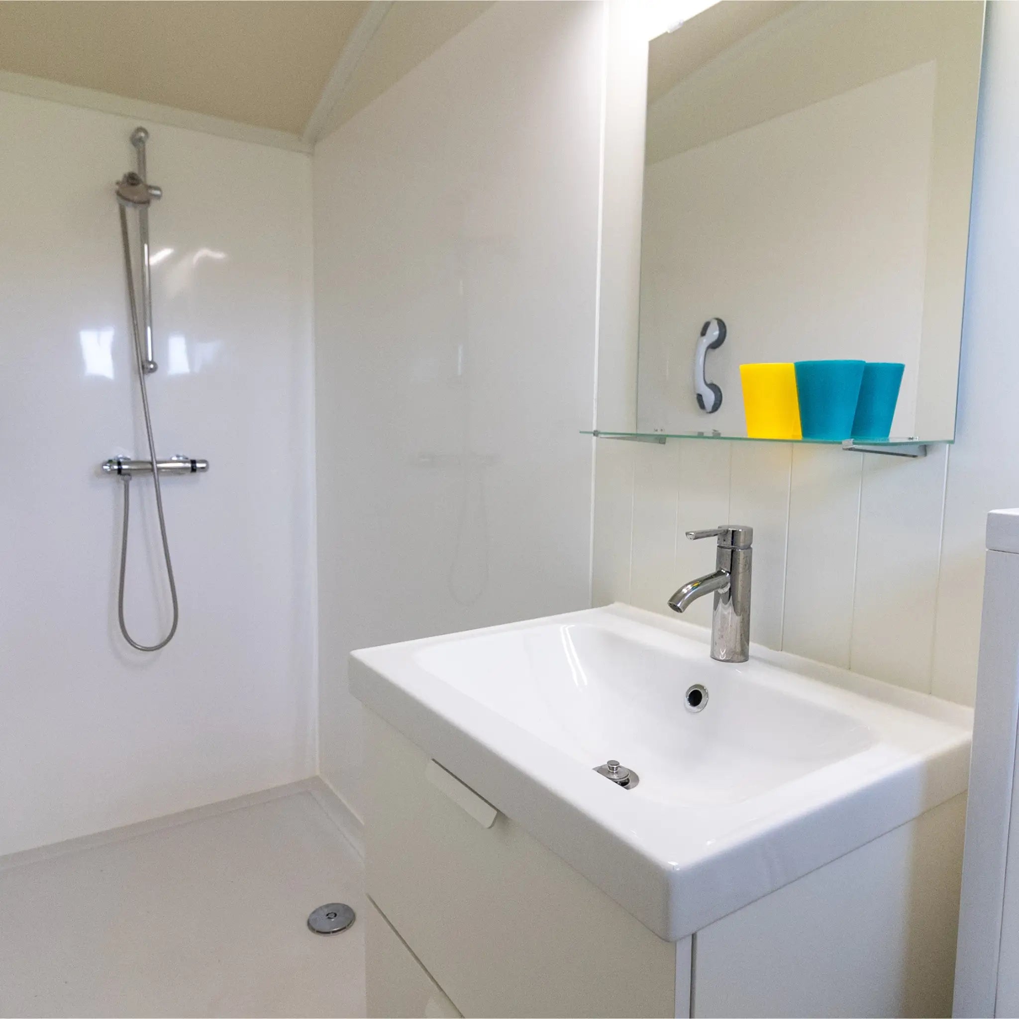 Modern shepherd’s hut bathroom with walk-in shower and vanity unit