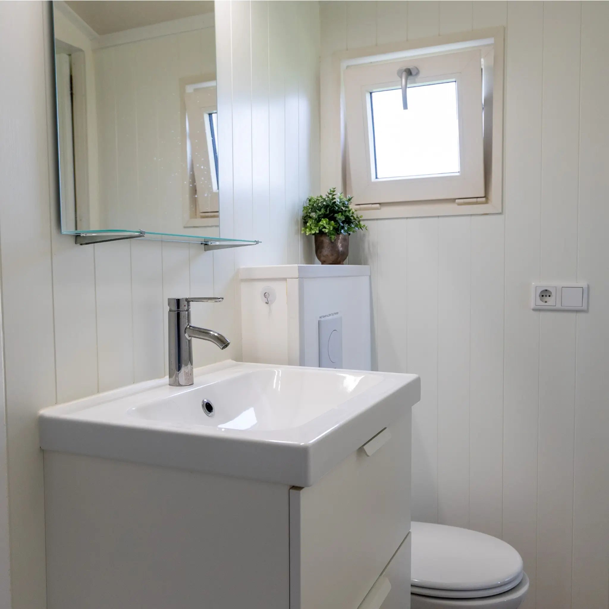 Contemporary shepherd’s hut bathroom with vanity unit, toilet and natural light