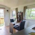 Bright dining space inside a modern 2 berth shepherd’s hut with countryside views
