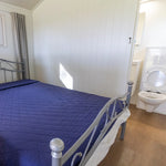 Double bedroom with ensuite bathroom inside a luxury shepherd’s hut