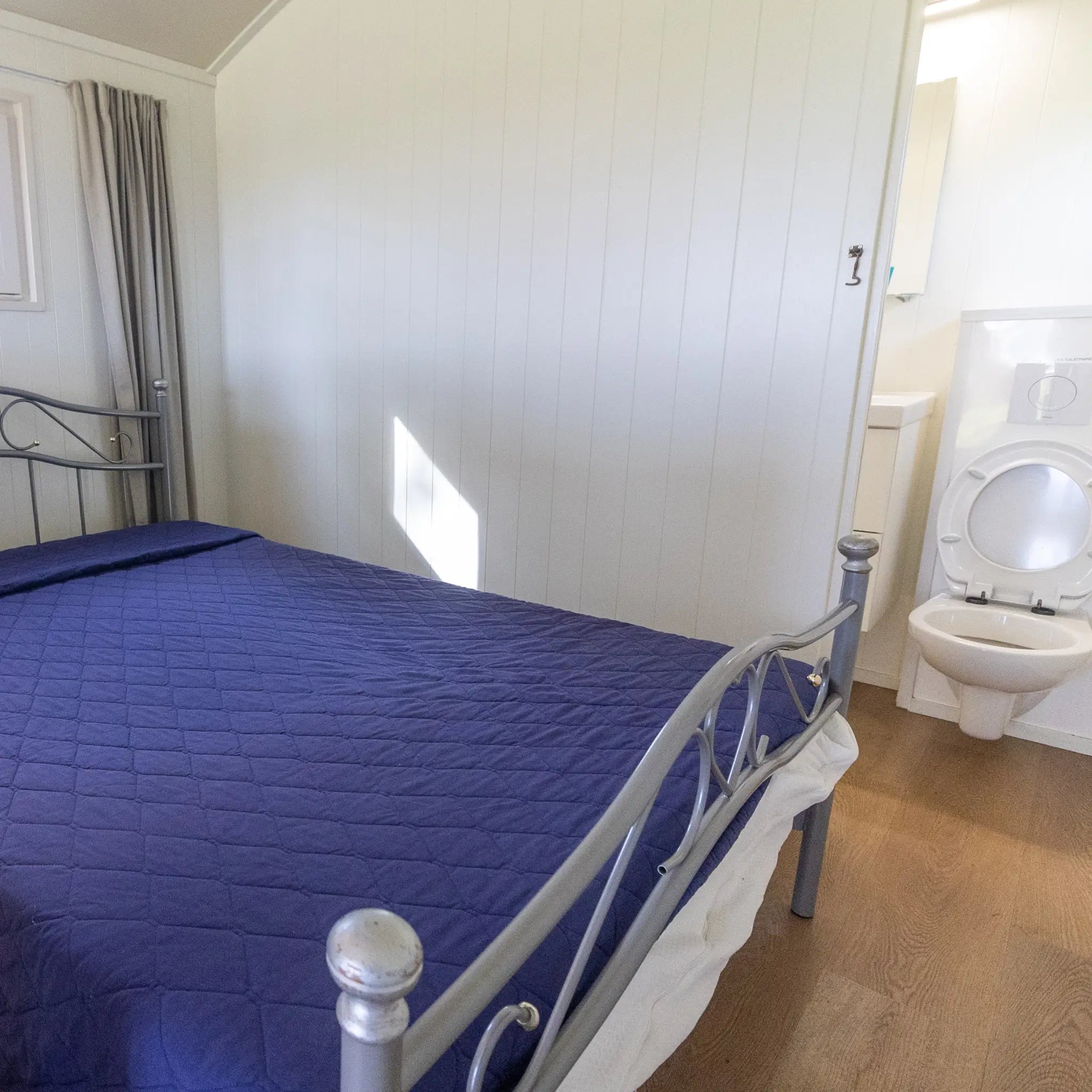 Double bedroom with ensuite bathroom inside a luxury shepherd’s hut
