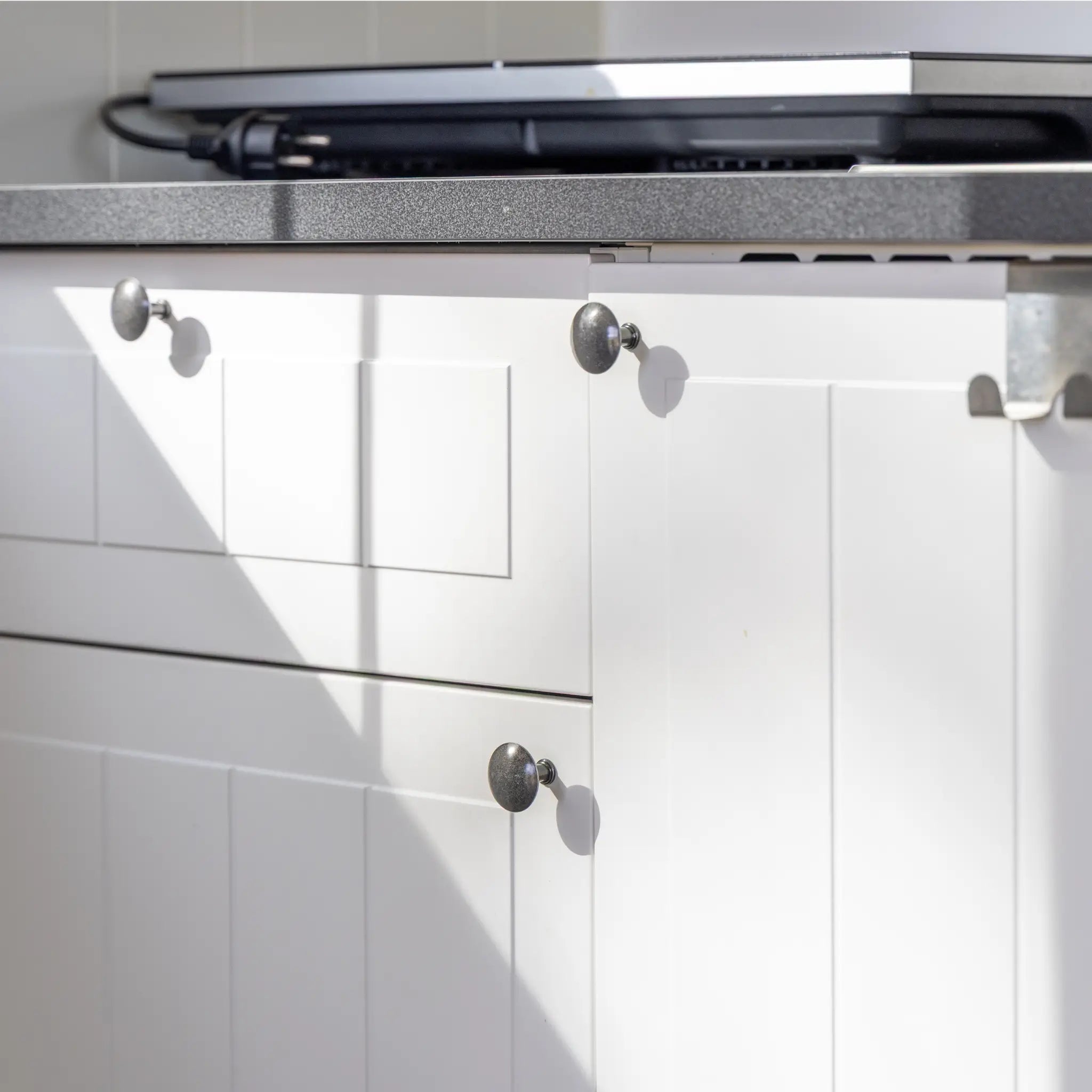 Modern kitchenette cabinets and storage inside a luxury shepherd’s hut