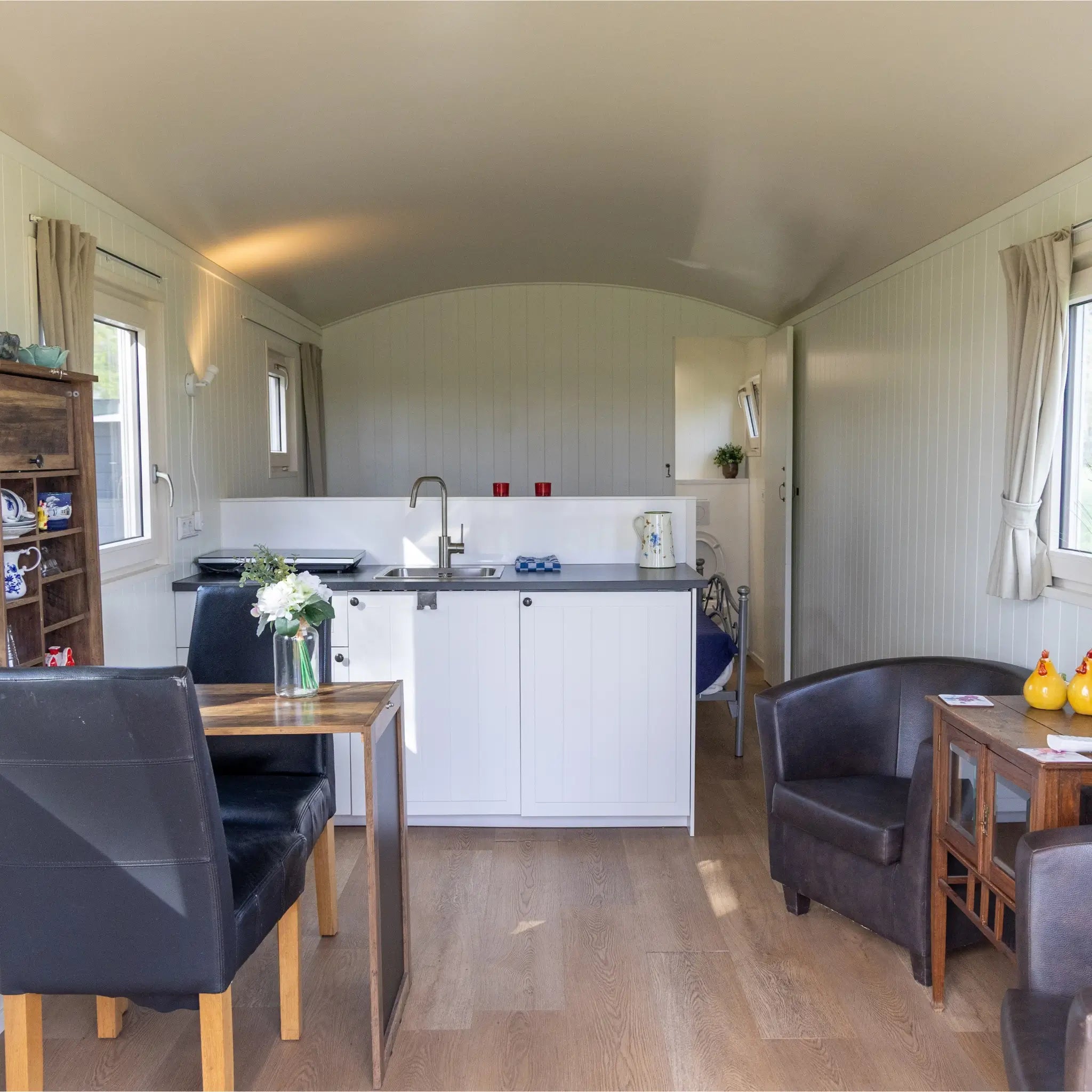 Spacious open layout with kitchenette, dining area and lounge inside a modern shepherd’s hut