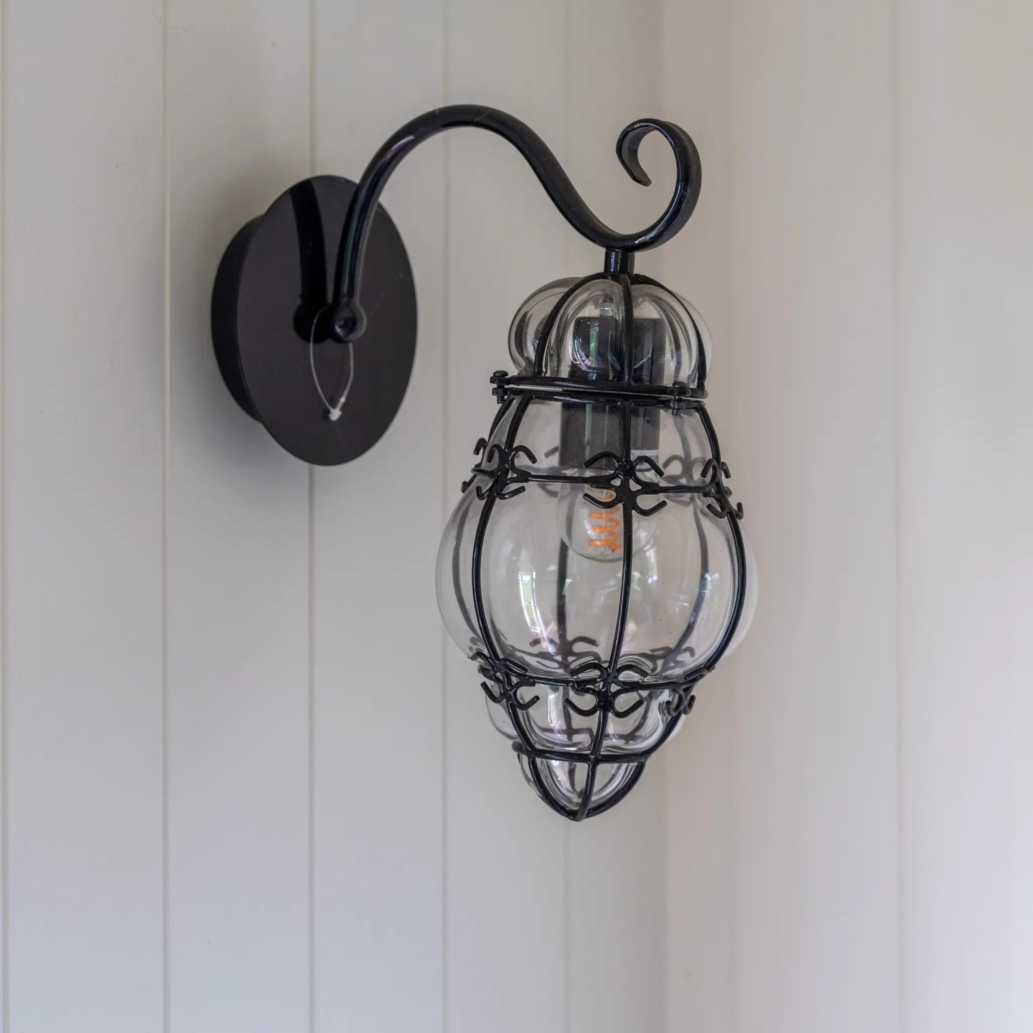 Decorative vintage-style wall light inside a luxury glamping shepherd’s hut