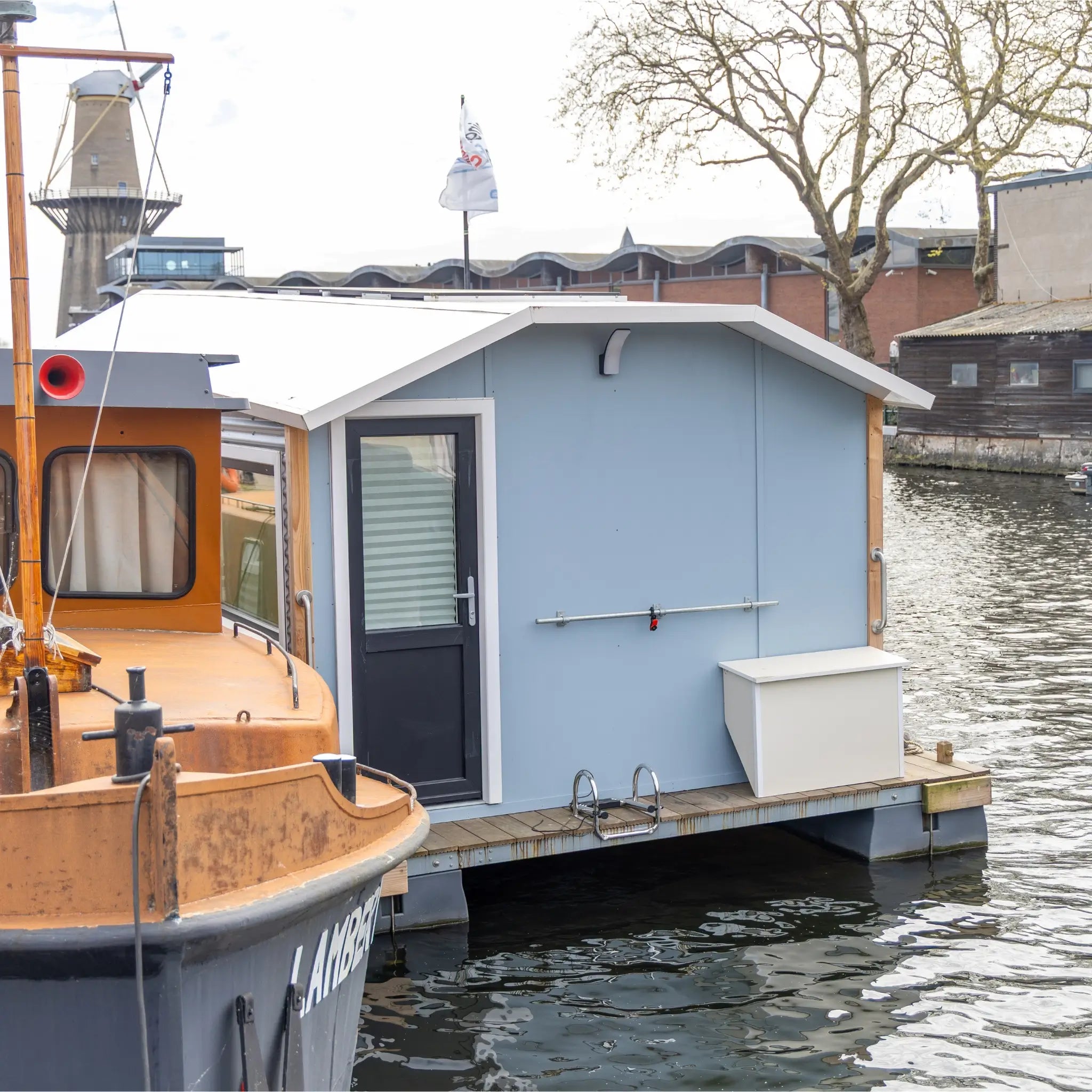 Rear exterior close-up of a floating shepherd’s hut with back door, storage box and floating deck platform.