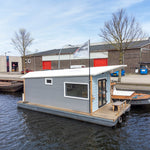 Side profile of a floating shepherd’s hut showcasing corrugated cladding and modern floating tiny home design.
