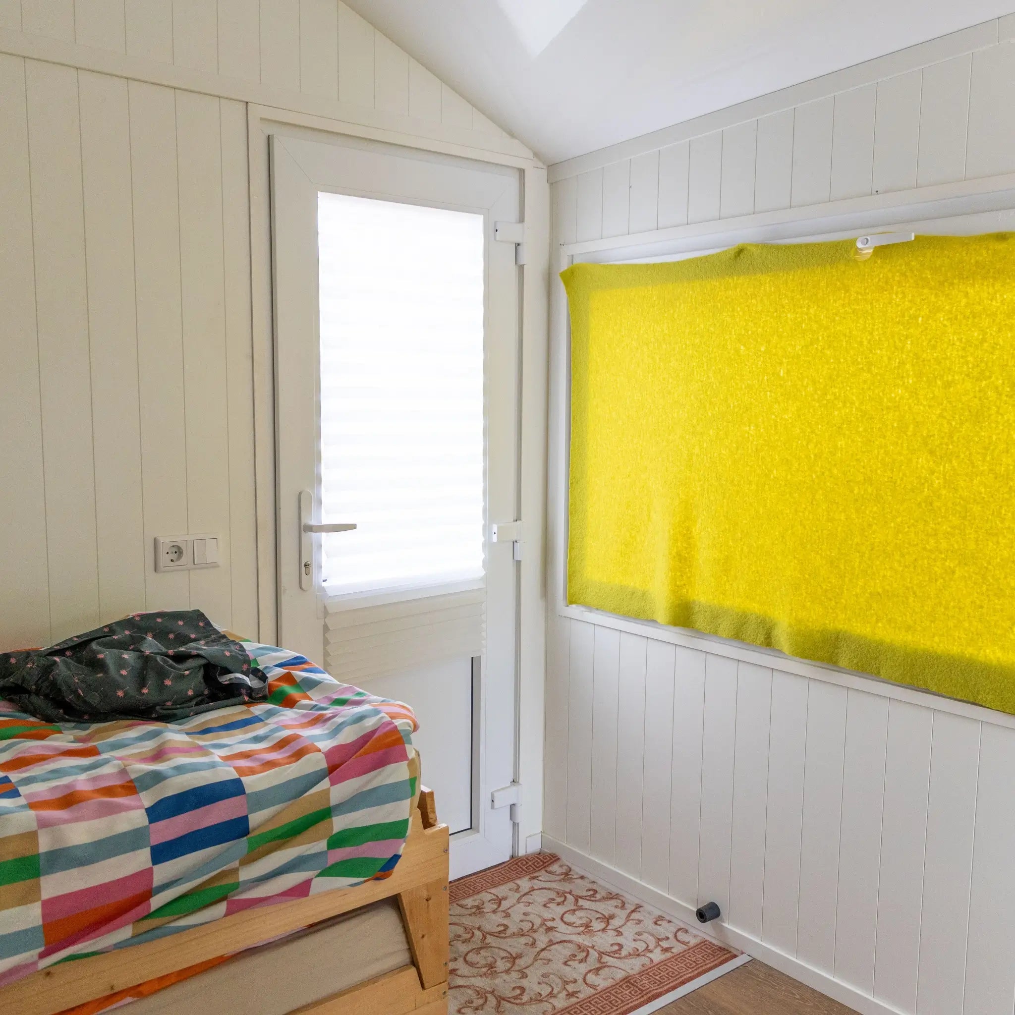 Interior rear entrance of a floating shepherd’s hut with compact bedroom, natural light and cosy cabin styling.