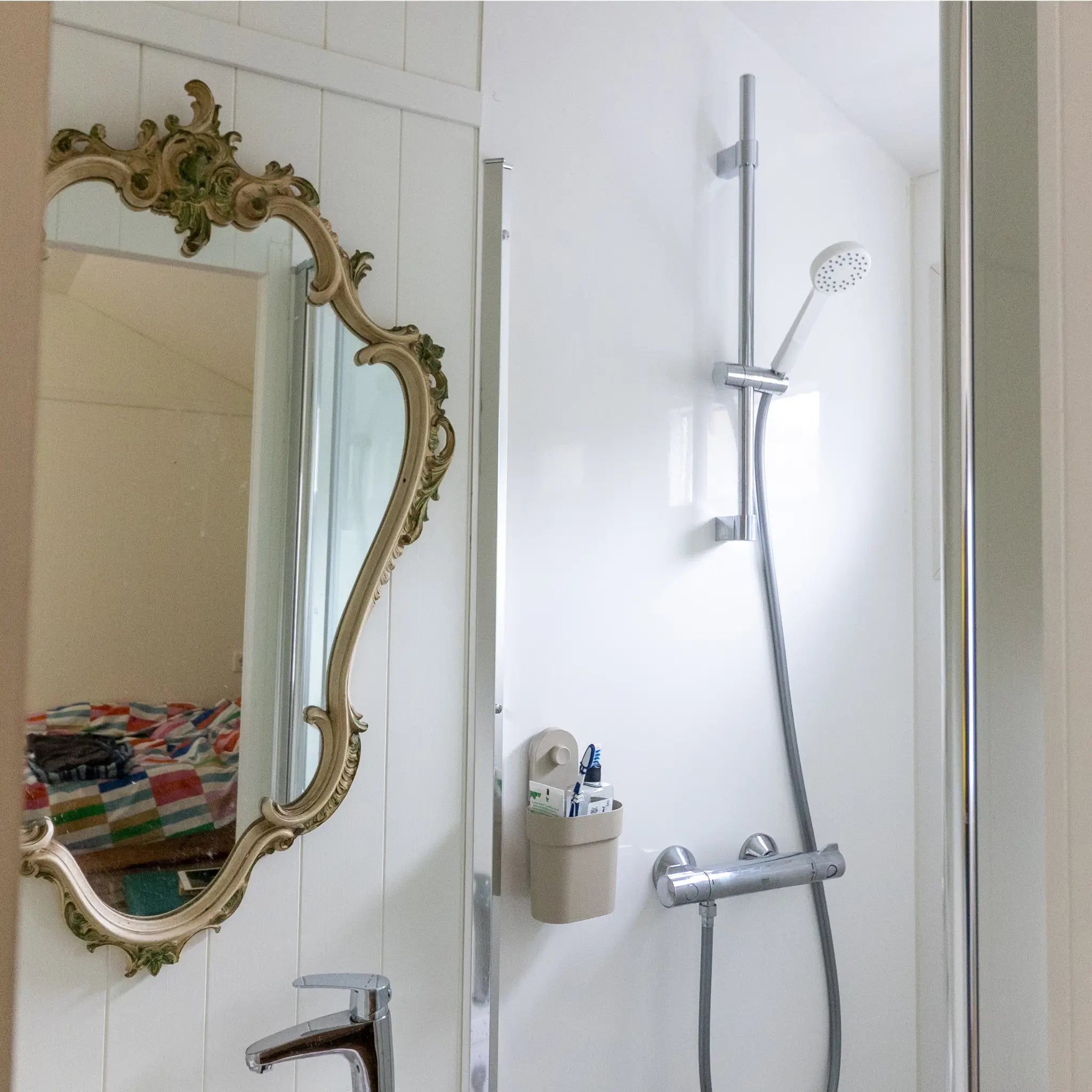 Bathroom interior of a floating shepherd’s hut featuring shower, vintage mirror and modern fittings.