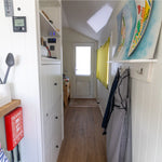 Interior hallway view of a floating shepherd’s hut connecting living area and bedroom with modern tiny home styling.