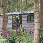 Side exterior of Bowridge 2 person shepherd’s hut surrounded by forest