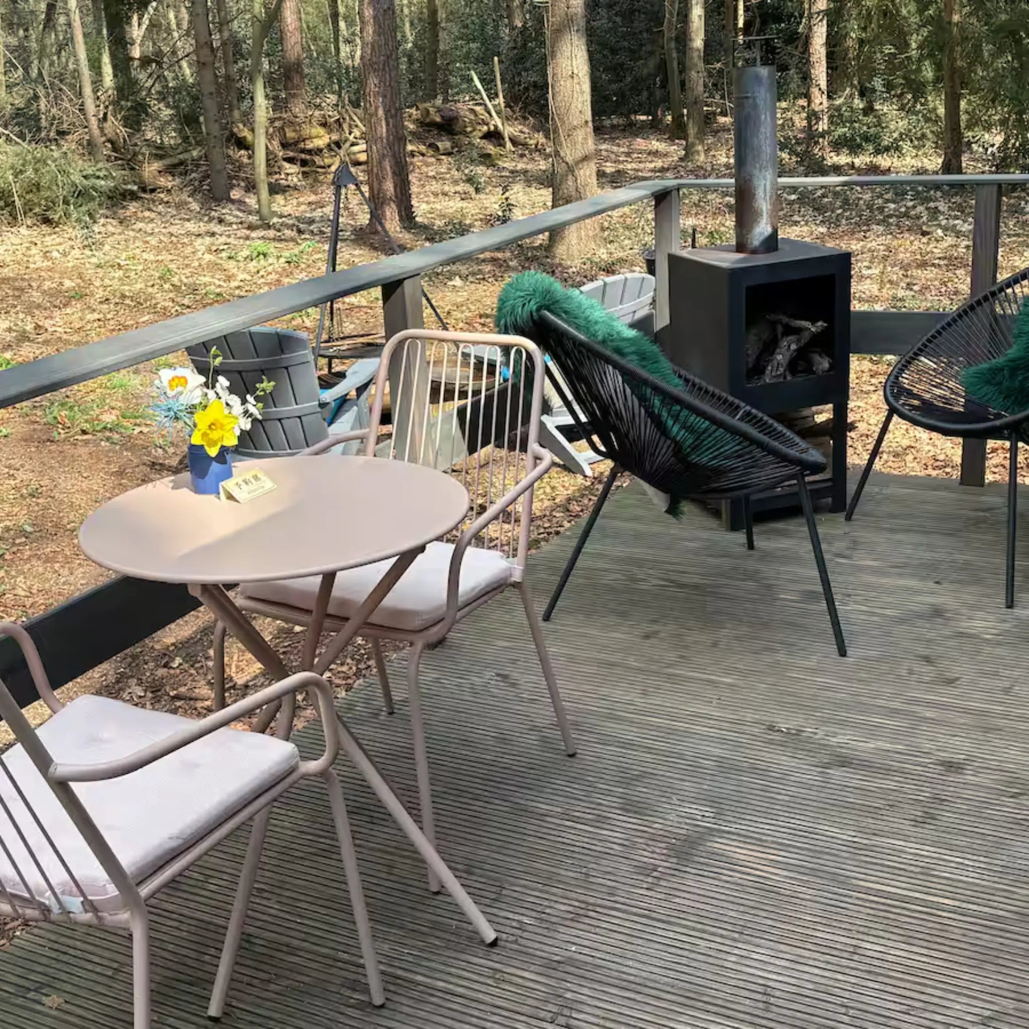 Outdoor dining table and chairs on the deck of the Bowridge shepherd’s hut