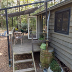 Rustic shepherd’s hut exterior with forest decking, outdoor dining area and charming woodland retreat setting.