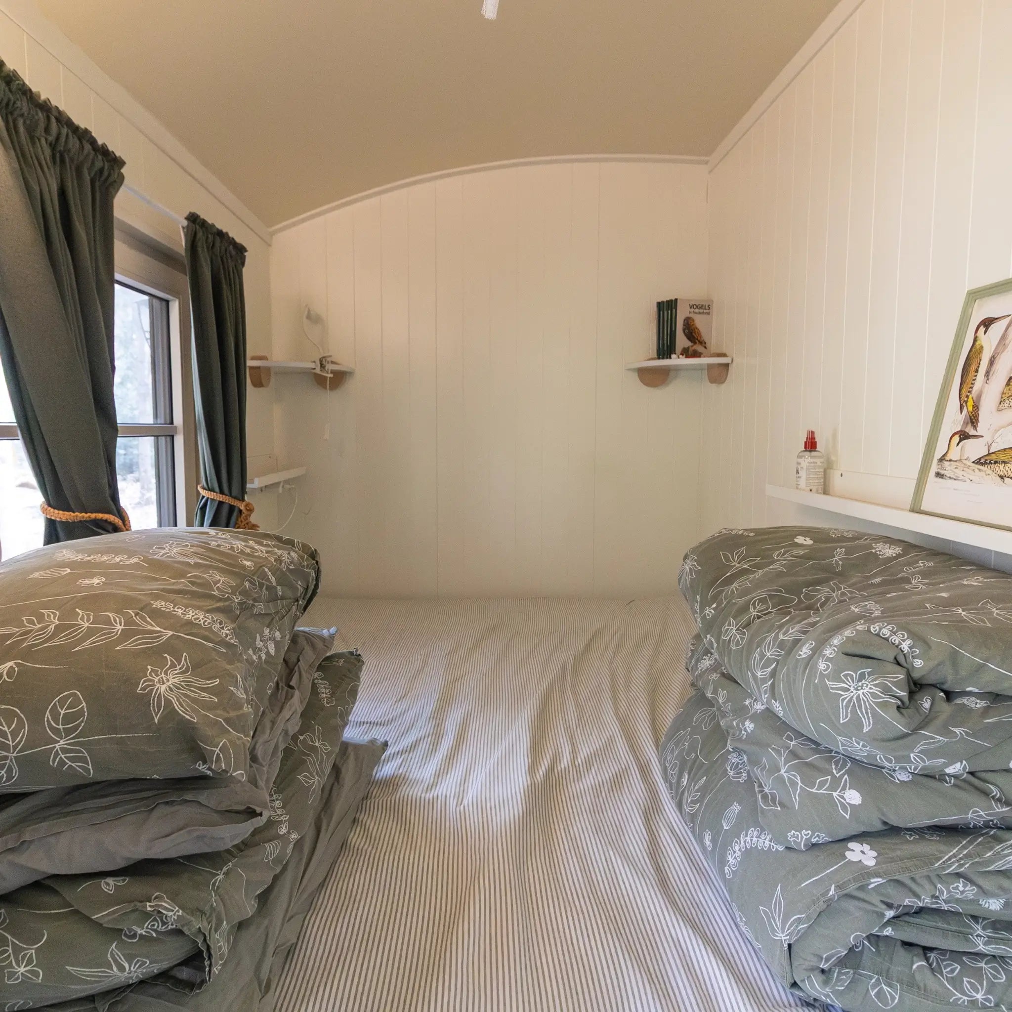 Cosy shepherd’s hut bedroom with comfortable double bed, soft bedding and calming woodland retreat styling.