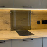 Close-up of induction hob and glass splashback on the wooden kitchen countertop