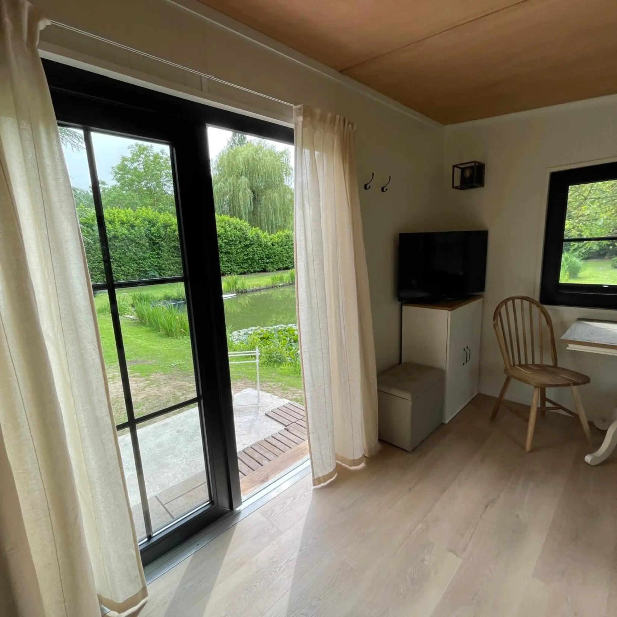 French doors overlooking the pond from the living area of The Elmstead 2 Person Shepherd’s Hut