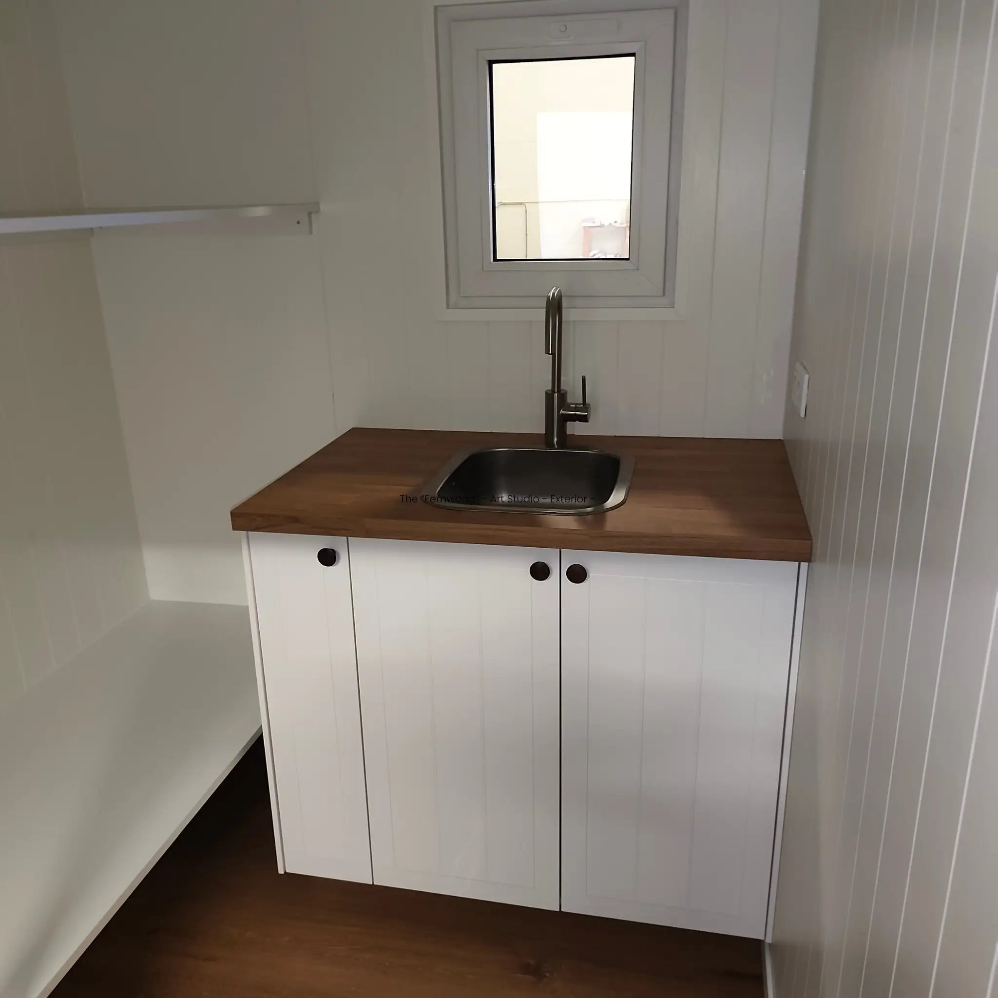 Interior sink and storage area in The “Fernwood” Art Studio with timber worktop and fitted cupboards