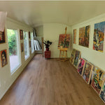 Open-plan interior of The “Fernwood” Art Studio with large windows, wood-effect flooring and artwork display space