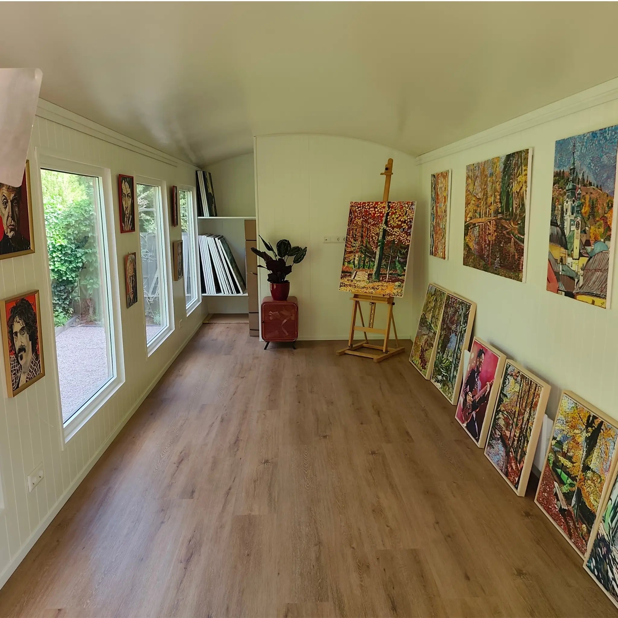 Open-plan interior of The “Fernwood” Art Studio with large windows, wood-effect flooring and artwork display space