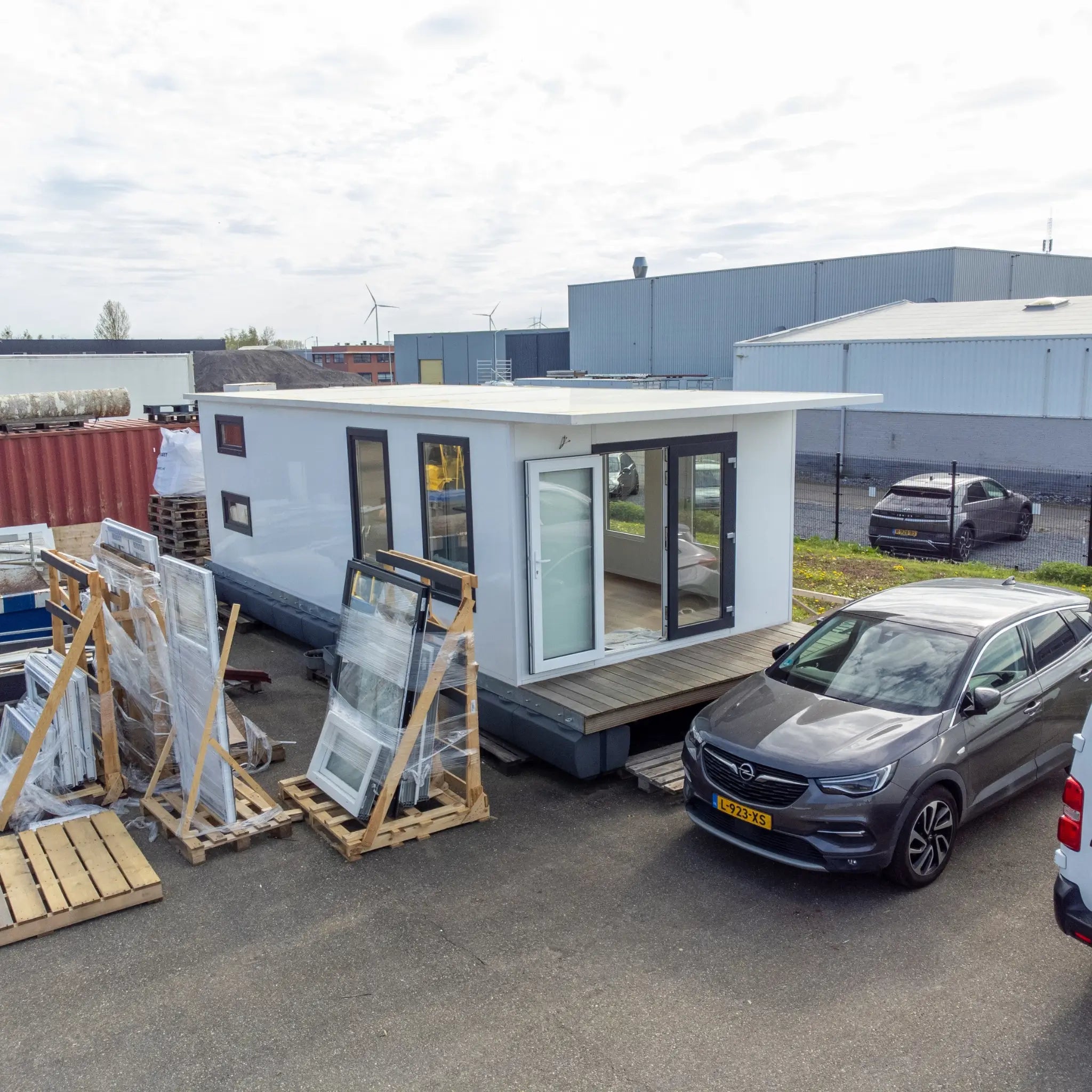 Elevated side exterior view of luxury floating shepherd’s hut with panoramic windows and compact waterside accommodation styling.