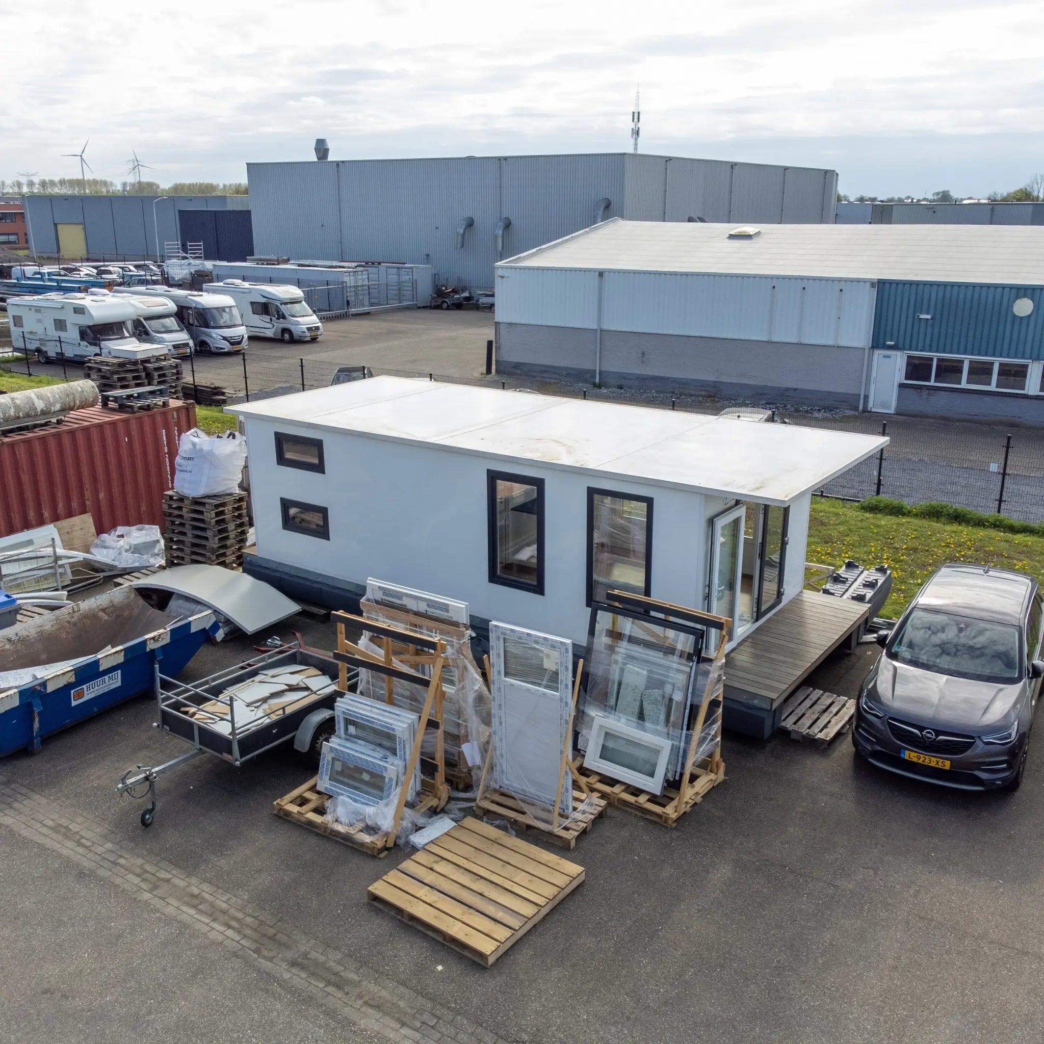 Elevated aerial side view of floating shepherd’s hut with compact modular design and timber decking entrance.