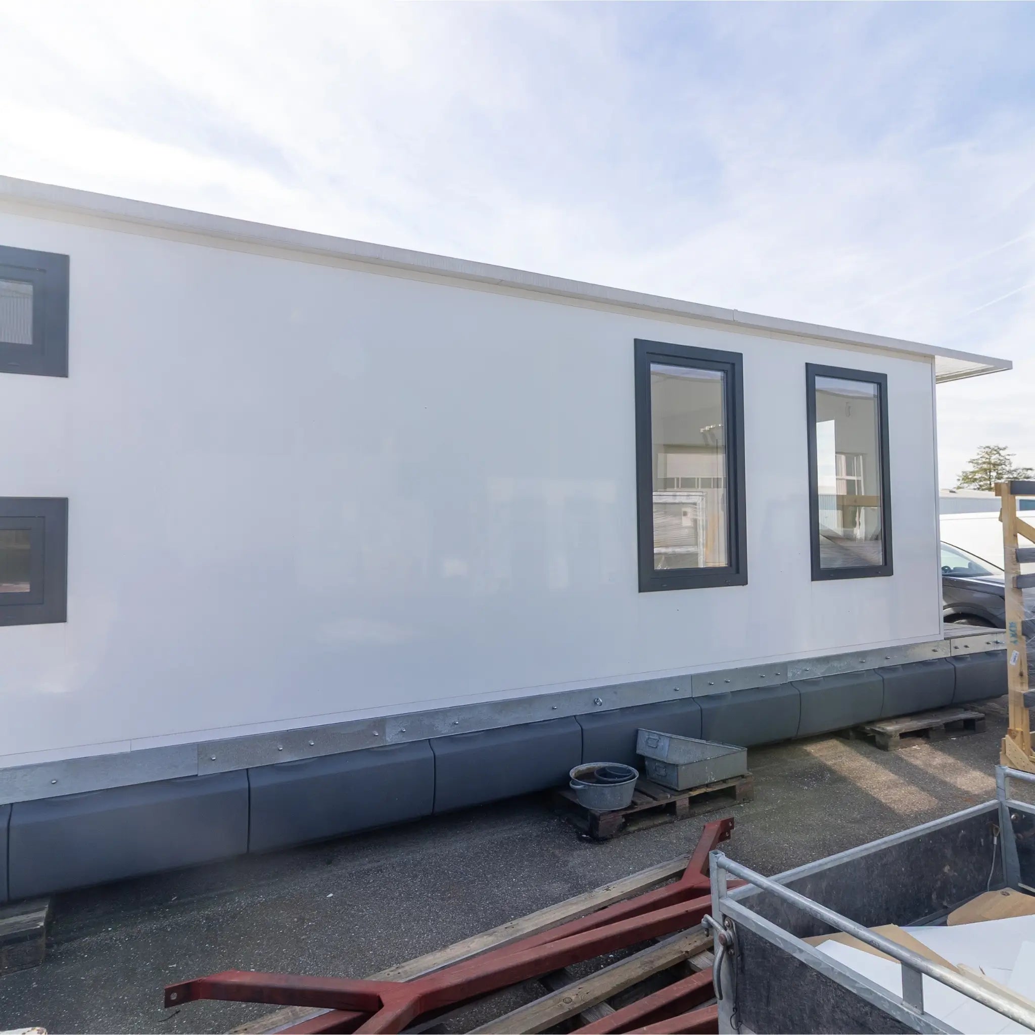 Full side profile of floating shepherd’s hut with modern windows, clean white exterior, and compact modular layout.