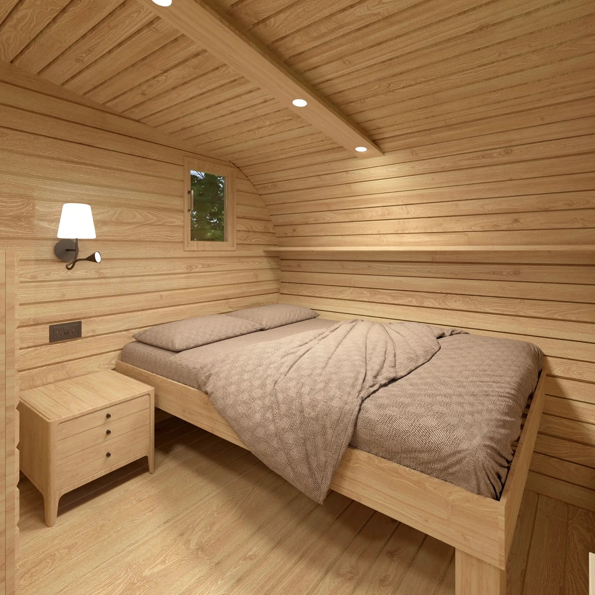 Double bed with bedside table inside The Grotto Pod featuring warm timber interior finishes.