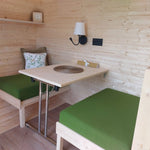 Convertible seating and dining table inside a luxury 3 person glamping pod