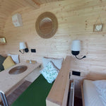 Convertible single bed beside double bed inside a 3 person glamping pod interior