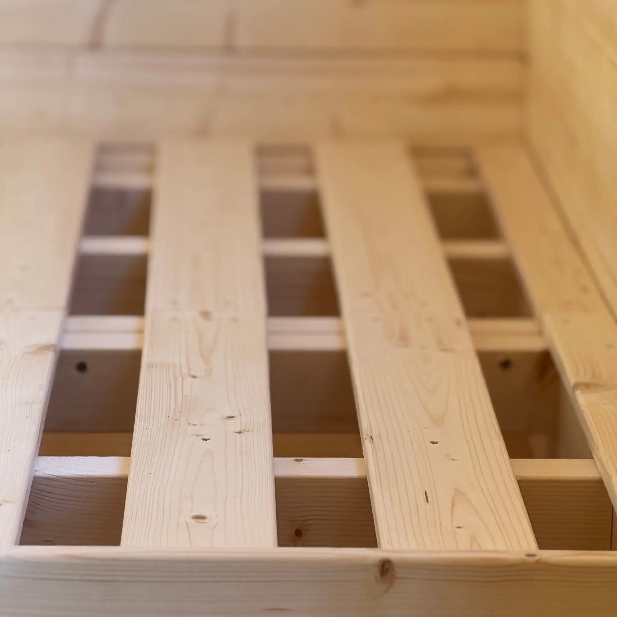 Close-up of solid wooden double bed frame base inside Grotto 3 berth glamping pod