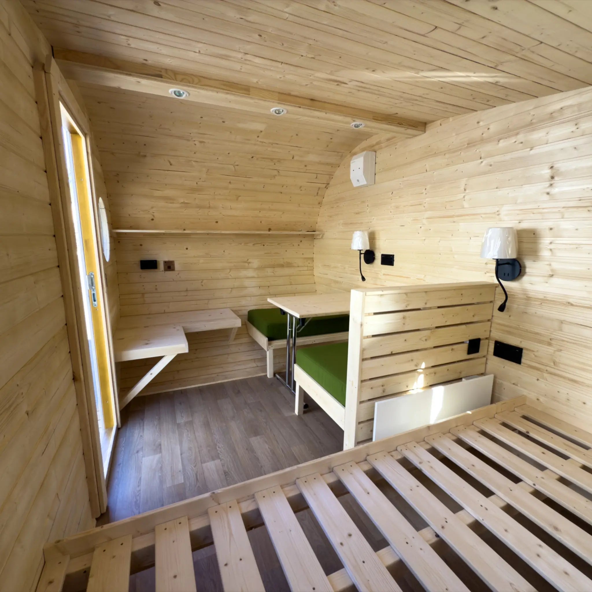 Open-plan interior layout of Grotto glamping pod showing beds, seating and compact living space