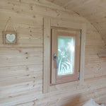 Opening timber framed side window inside a luxury 3 person glamping pod bedroom