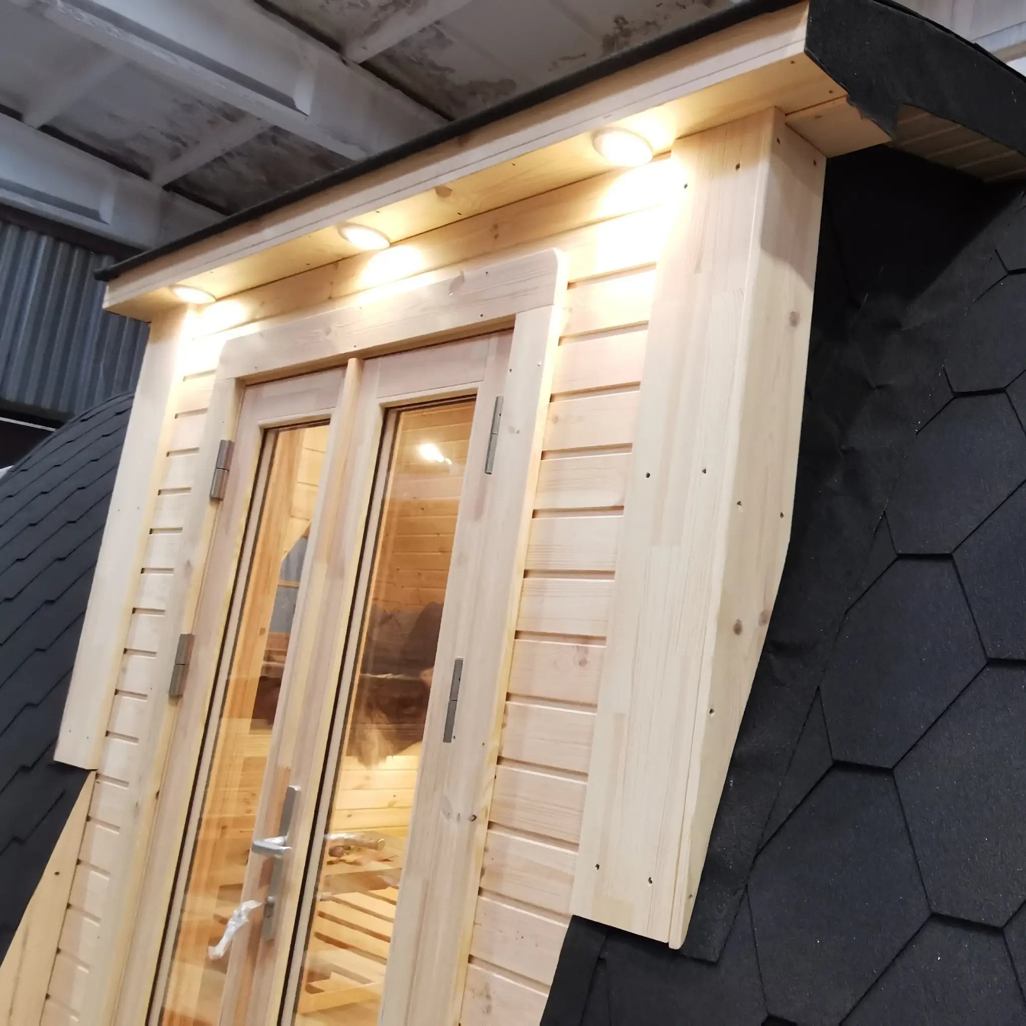 Close-up of timber-framed double entrance doors with exterior lighting on the Hearthwood Pod 5 Person Glamping Pod with disabled access
