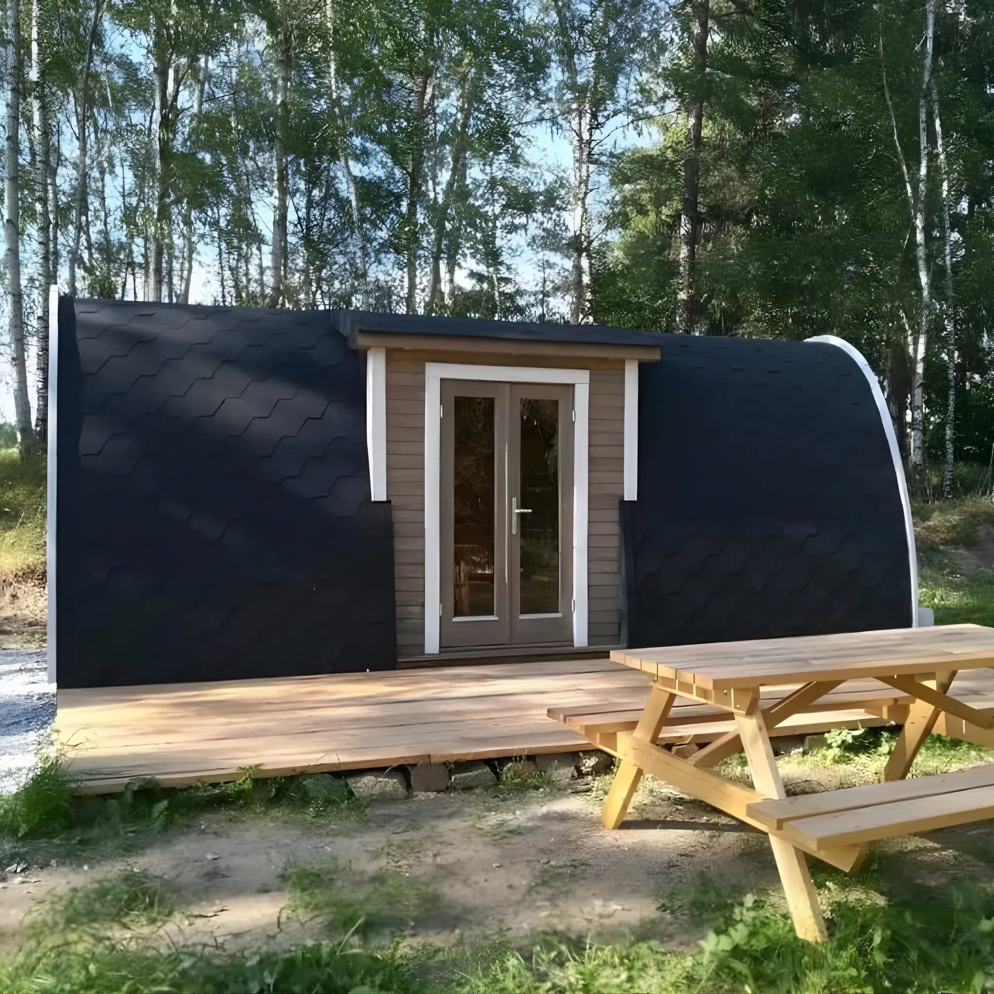 Hearthwood glamping pod set in a woodland garden with timber deck and picnic table at the front