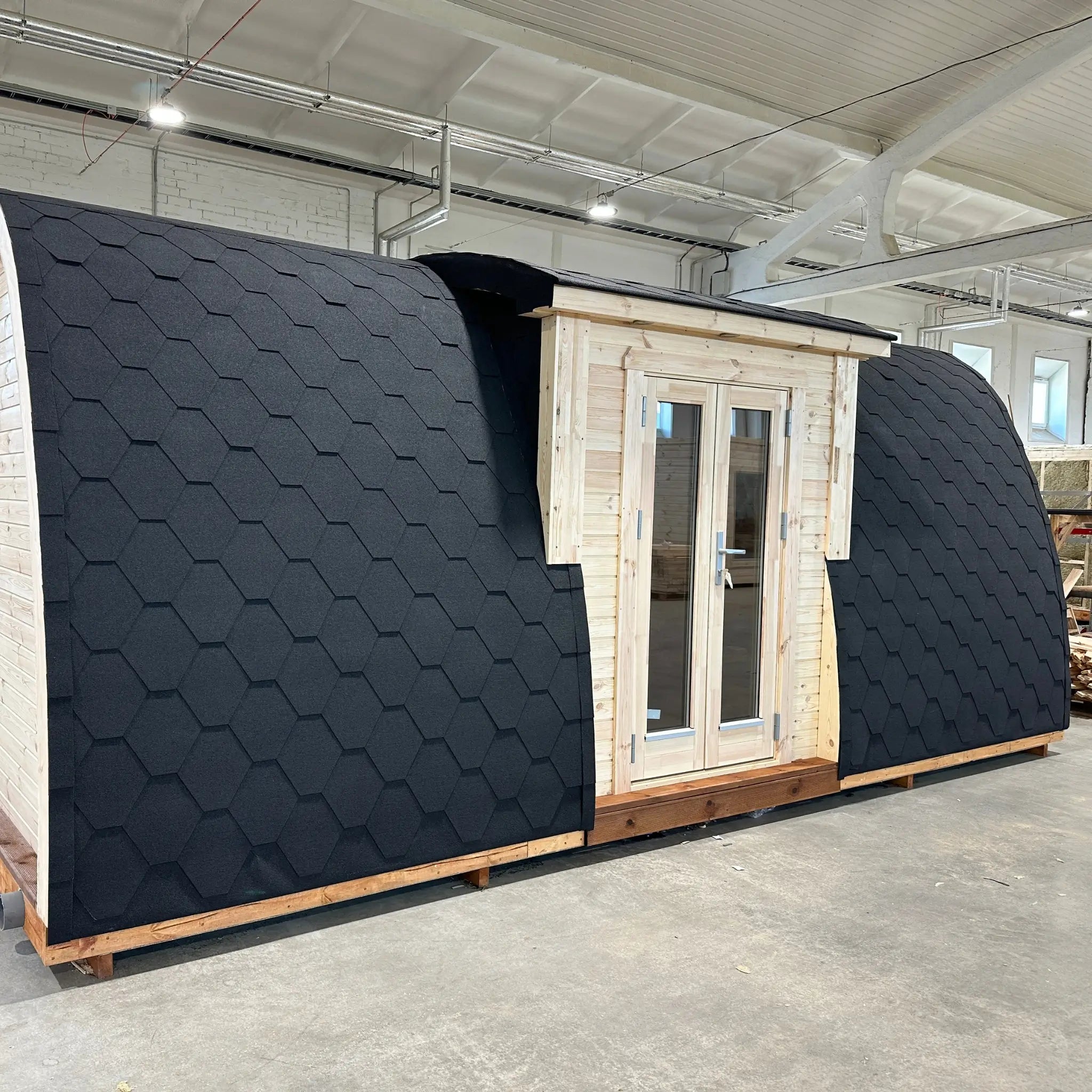 Full side profile of the Hearthwood pod showcasing its compact footprint and insulated curved structure