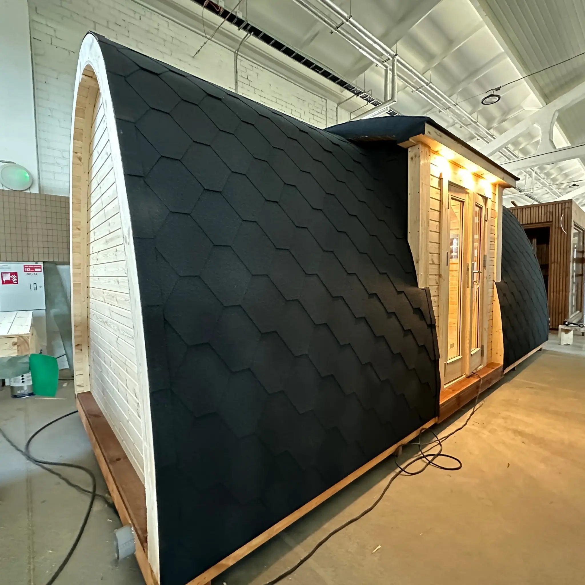 Side view of the Hearthwood glamping pod highlighting the curved barrel-style roof design