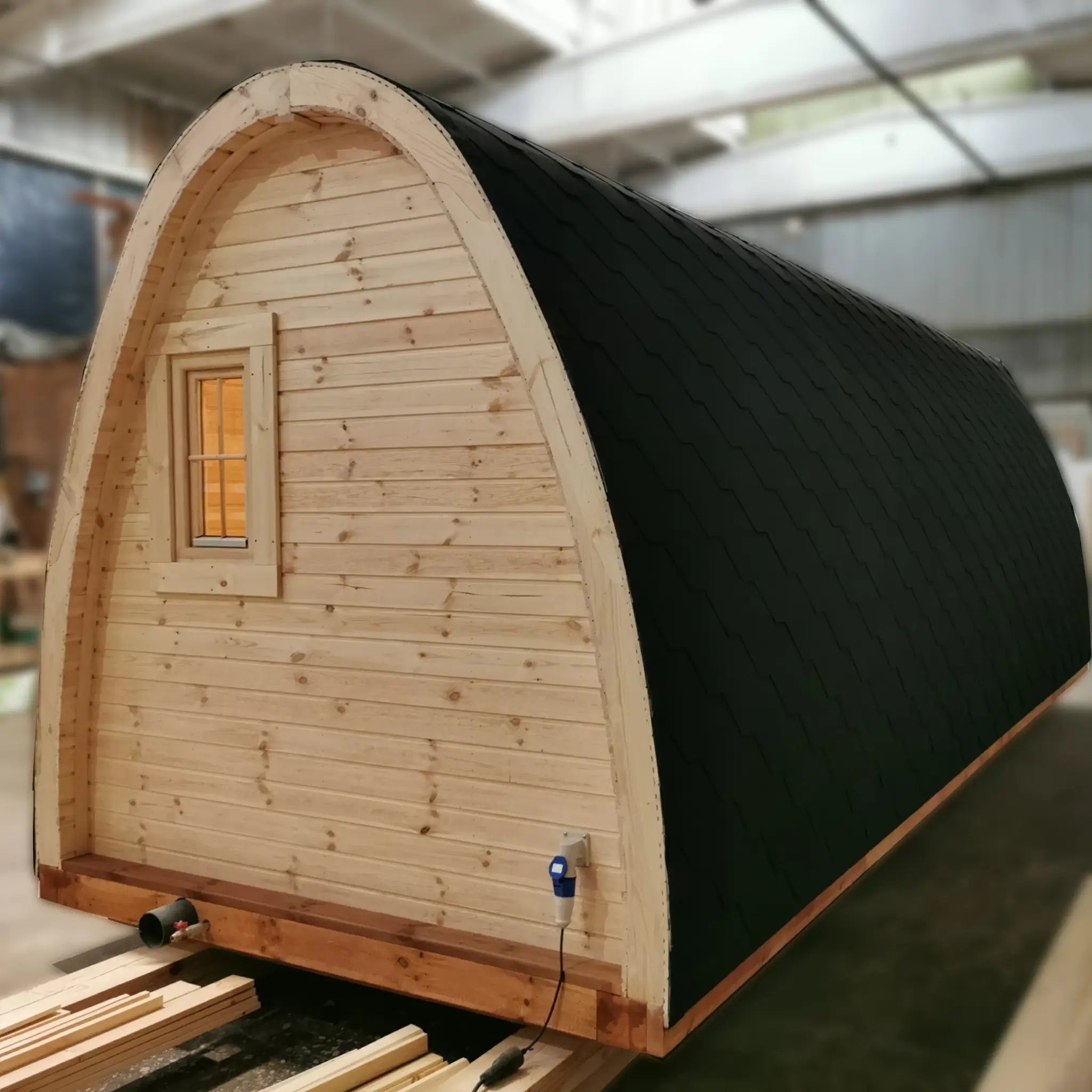 Rear angle view of The Hearthwood Pod luxury glamping pod showing rounded wooden structure and insulated roofing